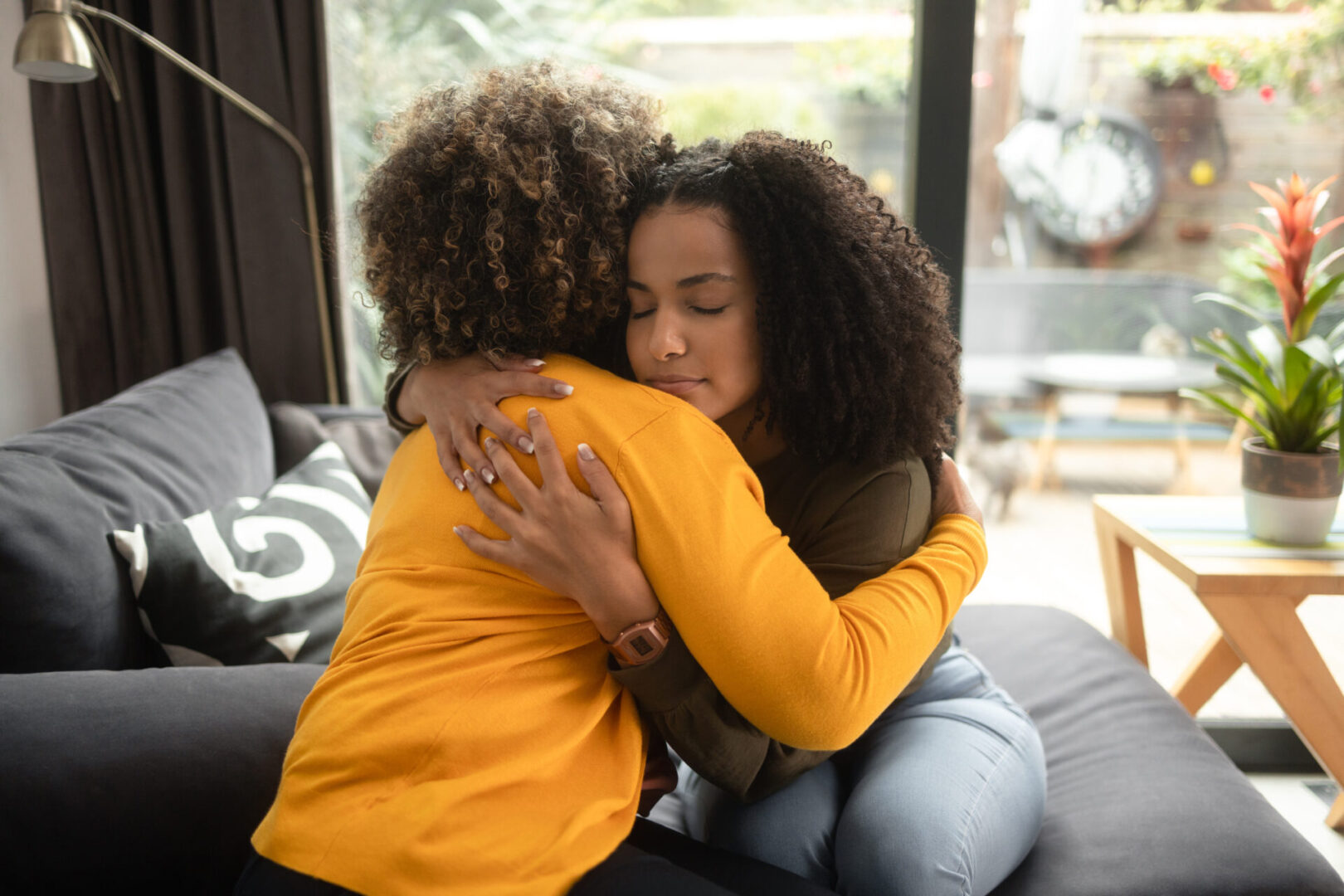 Two people hugging on a sofa.