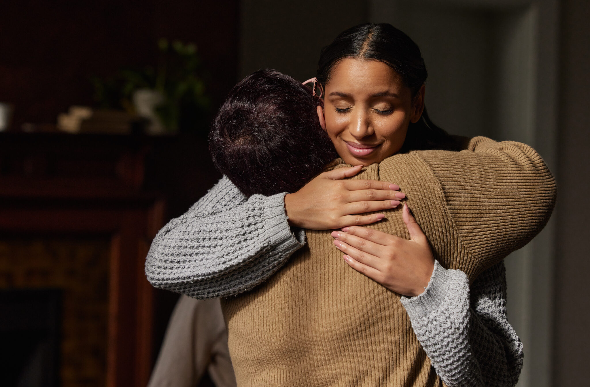 Two people sharing a warm embrace indoors.